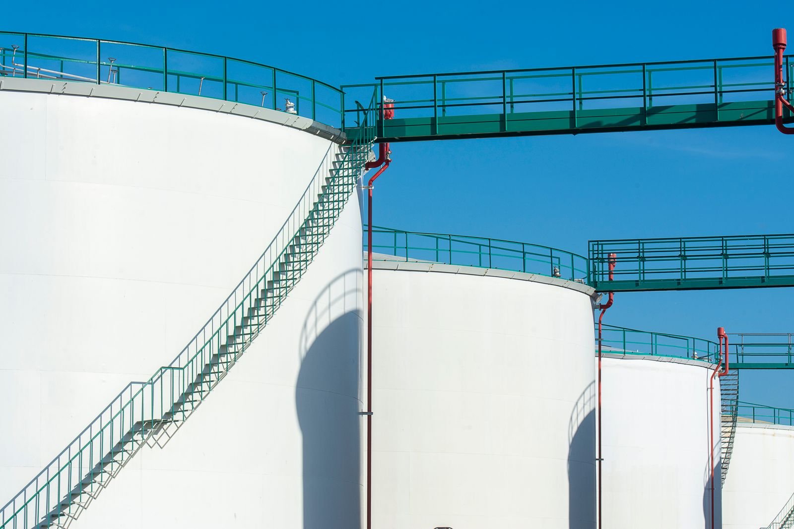Large industrial storage tanks with a walkway