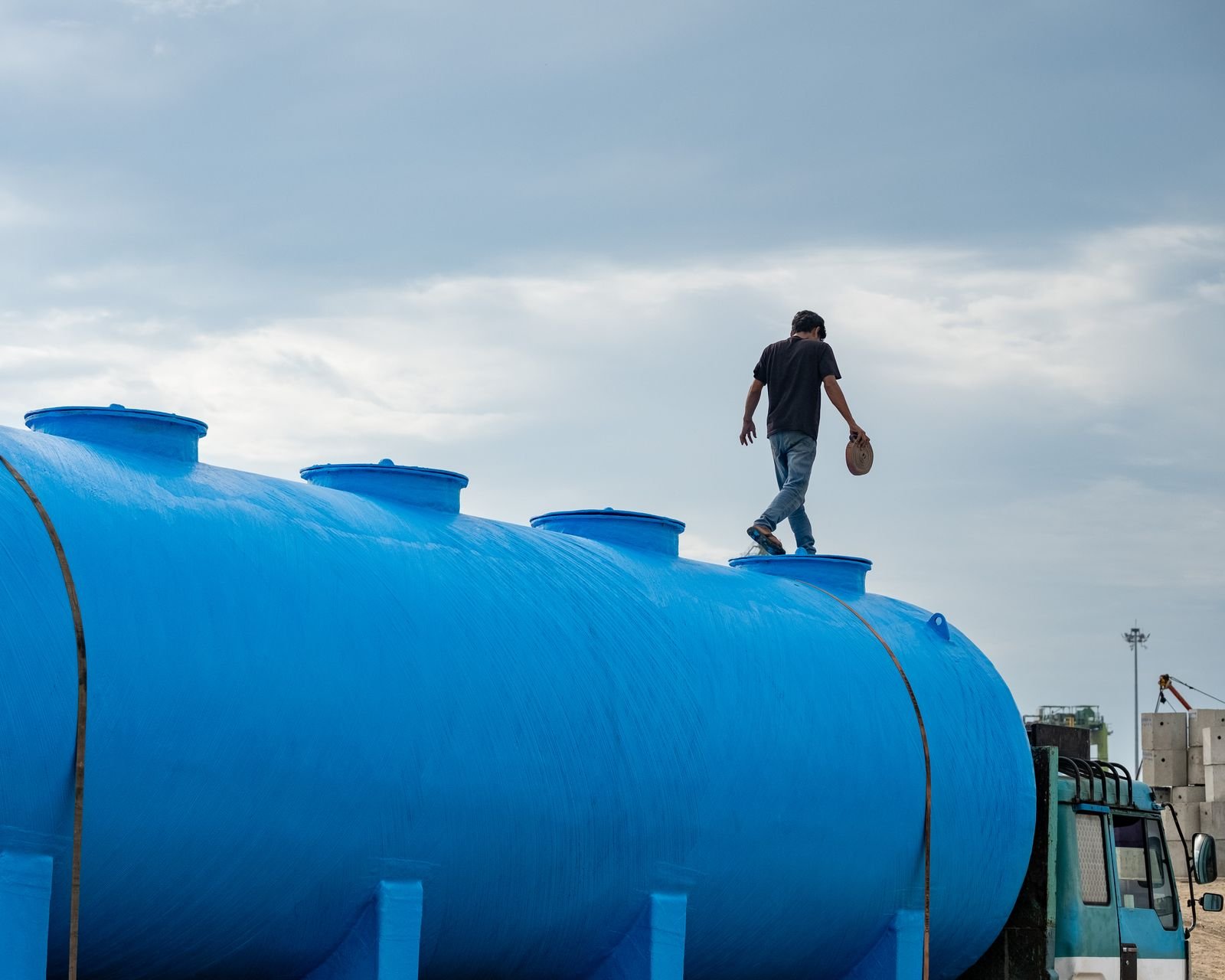 Technician walking on top of a large blue water tank