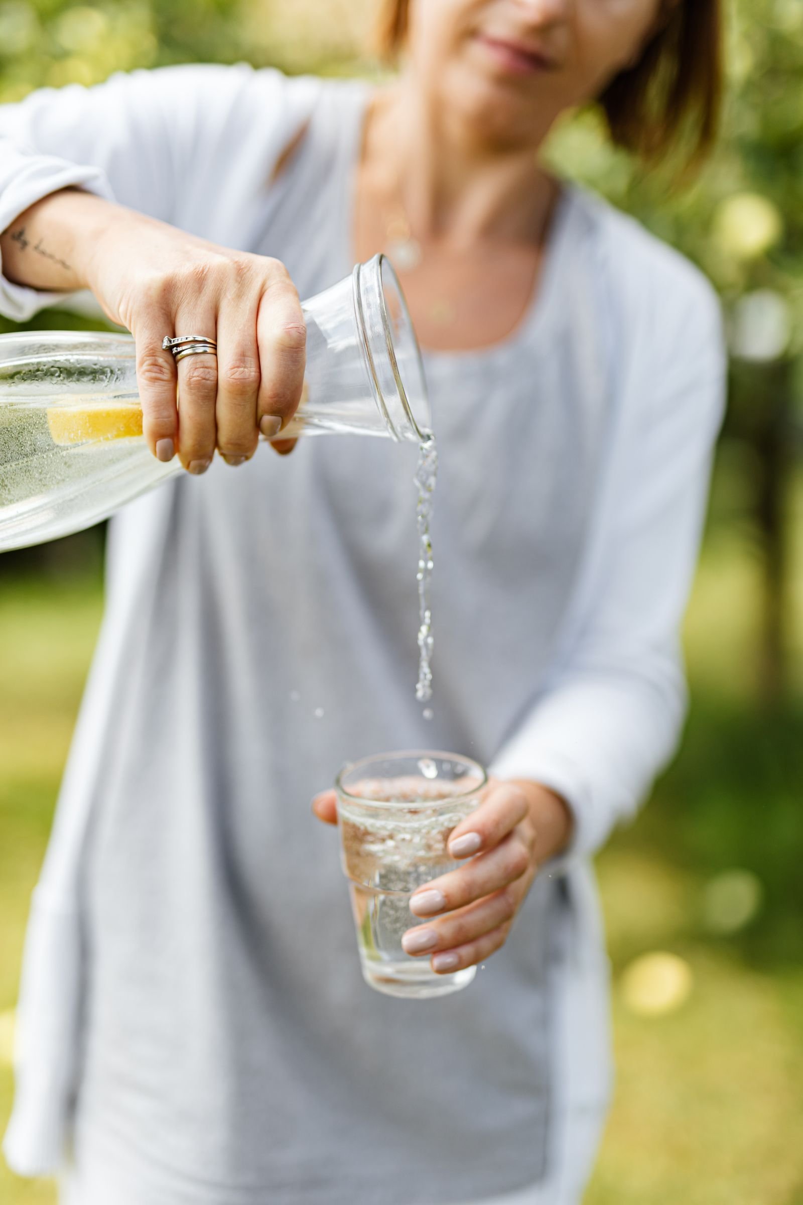 Person pouring drinking water into a glass